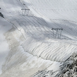 Protective textile covering to delay snow melting on skiing slope with ski lift, Presena Glacier, Italian Alps, Italy