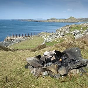 Remnants of fire left by campers near coast, Craignish, Argyll and Bute, Scotland, april