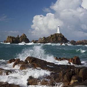 Rocky coastline with lighthouse in background, La Corbiere Lighthouse, La Corbiere, St