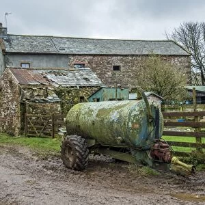 Slurry tanker and farm buildings, Cumbria, England, March