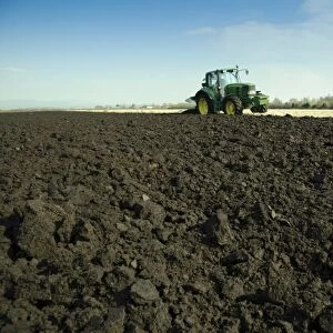 Tractor with plough, ploughing arable field, Pilling, Lancashire, England, march