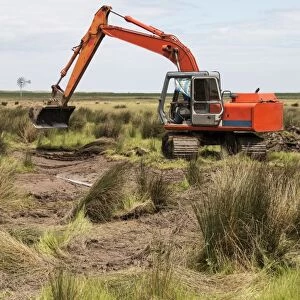 Using a digger excavator for habitat restoration work on Deepdale Marsh, Burnham Deepdale, North Norfolk