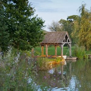 View of boathouse on fishing pond at sunset, Little Budworth, Tarporley, Cheshire, England, september