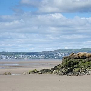 View of coast with rocky outcrop at low tide, looking towards Grange-over-sands, Silverdale, Morecambe Bay, Lancashire