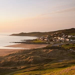 View of coastline and seaside resort at sunset, with Morte Point in distance, viewed from Potters Hill, Woolacombe
