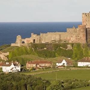 View fields and village towards castle, Bamburgh Castle, Northumberland, England, may