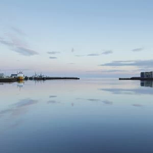 View of harbour with calm water at sunrise, Hafnarfjordur, Iceland, August