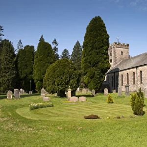 View of headstones and yew trees in churchyard of parish church, St. Oswalds Church, Ravenstonedale, Westmorland