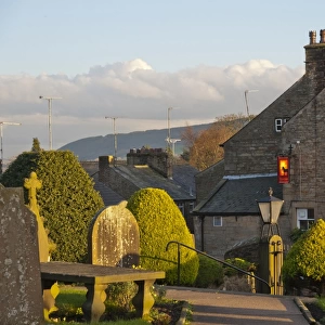View of pub and village from churchyard in evening sunlight, Chipping, Forest of Bowland, Lancashire, England, november