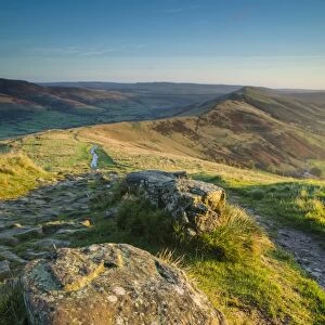 View of rocks beside path on moorland at dawn, looking from Mam Tor to Hollins Cross, High Peak District