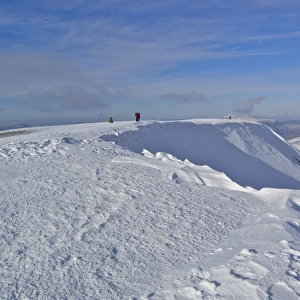 View of snow covered fell summit with walkers, Helvellyn, Eastern Fells, Lake District N. P. Cumbria, England, february