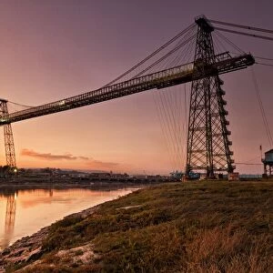 View of transporter bridge over river at twilight, Newport Transporter Bridge, River Usk, Newport, South Wales, Wales