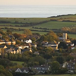 View of village, church, farmland and sea in distance, Preston, Dorset, England, october