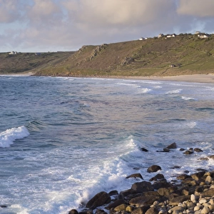 View of waves and coastline in evening sunlight, Sennen Cove, Sennen, Cornwall, England, May