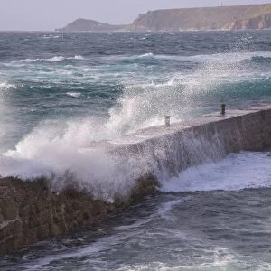 Waves breaking over harbour wall, looking towards Cape Cornwall, Sennen Cove, Sennen, Cornwall, England, May