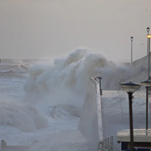 Waves crashing against seawall of seaside town during tidal surge, Sheringham, North Norfolk, England, December 2013