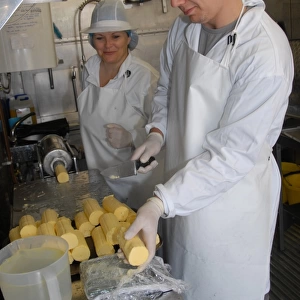 Workers weighing out butter patts, making organically made butter from unpasteurized milk, on organic dairy farm