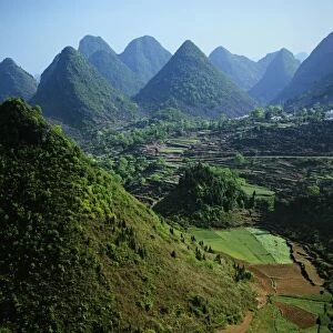 Asia, China, Guizhou Province, Xingyi. Limestone karst mountains surround farm fields