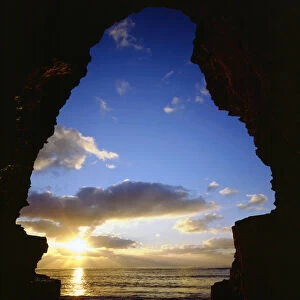 USA; California; San Diego. ; Sunset thru a cave at Sunset Cliffs on the Pacific Ocean