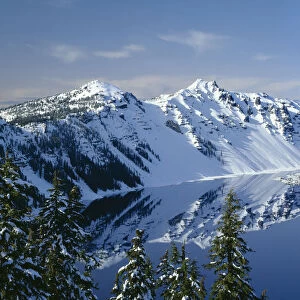 USA, Oregon. Crater Lake National Park, winter snow on west rim of Crater Lake with The Watchman