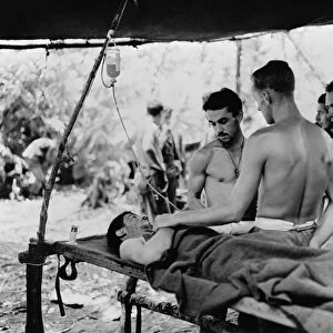 WWII: NEW GUINEA, c1943. Medics administering blood plasma to a wounded American