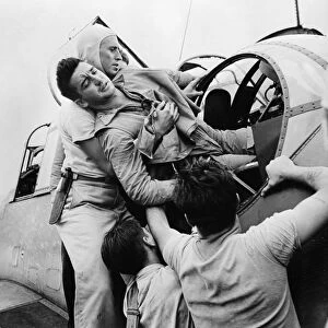 WWII: PILOT, c1943. An American pilot being removed from his plane on the deck
