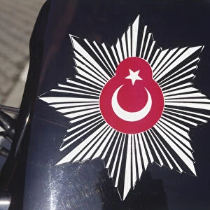 Asia, Turkey, badge of the Turkish police, red Turkish flag inside black and white eight-pointed star, displayed against black background
