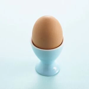 Whole boiled egg in blue egg cup