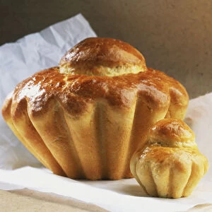 Close-up of an individual brioche and the larger brioche a tete