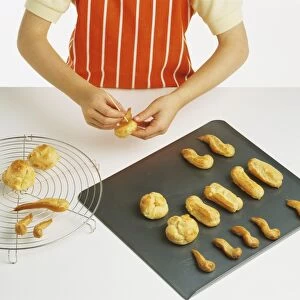 Cook taking cooked pastry shapes from baking tray