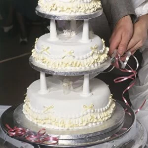 Couple cutting wedding cake, close-up