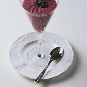A dessert glass containing a blackberry dessert