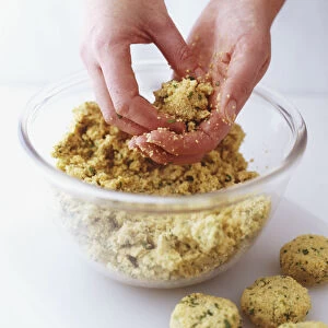 Falafel mixture being moulded into balls, side view