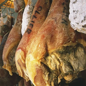 France, Jambon d Avergne, hanging haunches of ham, low angle view