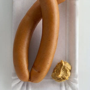 Two Frankfurter sausages with mustard