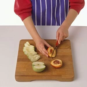 Girl slicing peach on chopping board, apple slices nearby, close-up