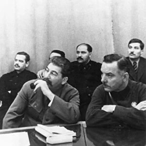 Joseph stalin (front, left) sits with k, e, voroshilov at a conference of best combine workers and soviet government, left to right, back: a, a, andreyev, l, m, kaganovich, v, j, chubar, ussr, 1930s