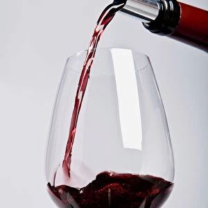 Pouring red wine through spout, close-up