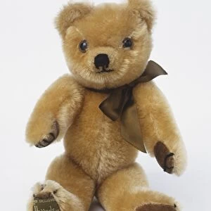 Sitting teddy bear with silky brown bow tie, front view
