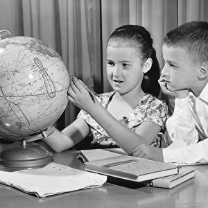 Boy and girl looking at globe