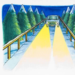 Car with bright headlights on driving along snow-covered road lined with trees