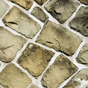 Old stone wall with irregular bricks