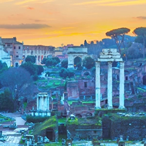 The ruins of Temple of Castor and Pollux and Arch of Titus at dawn in the Roman Forum, Rome, Italy