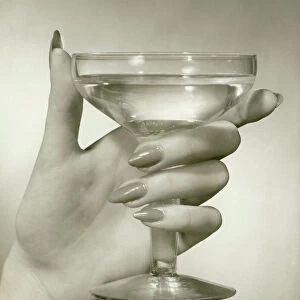 Womans hand holding martini, close-up