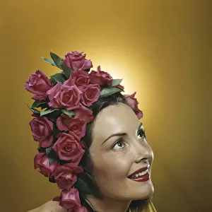 Young woman wearing flowers in hair, smiling, close-up