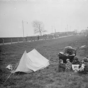 Children have a picnic on a bit of grass next to the road. 1938