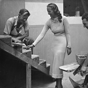 Miss Elmina Humphreys, the radio Queen, holding a nail for one of the workmen building