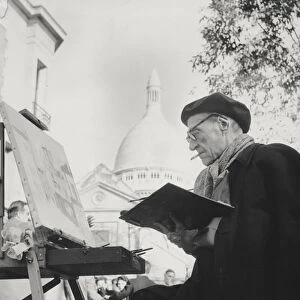 The artist Maurice Utrillo painting at his easel in Montmartre, Paris, 1950s (photo)