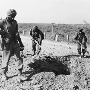 Indian soliders searching for mines along a dirt road, 1941 (b / w photo)