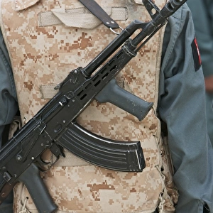 An AK-47 rests on the sling of an Afghan Police Officer